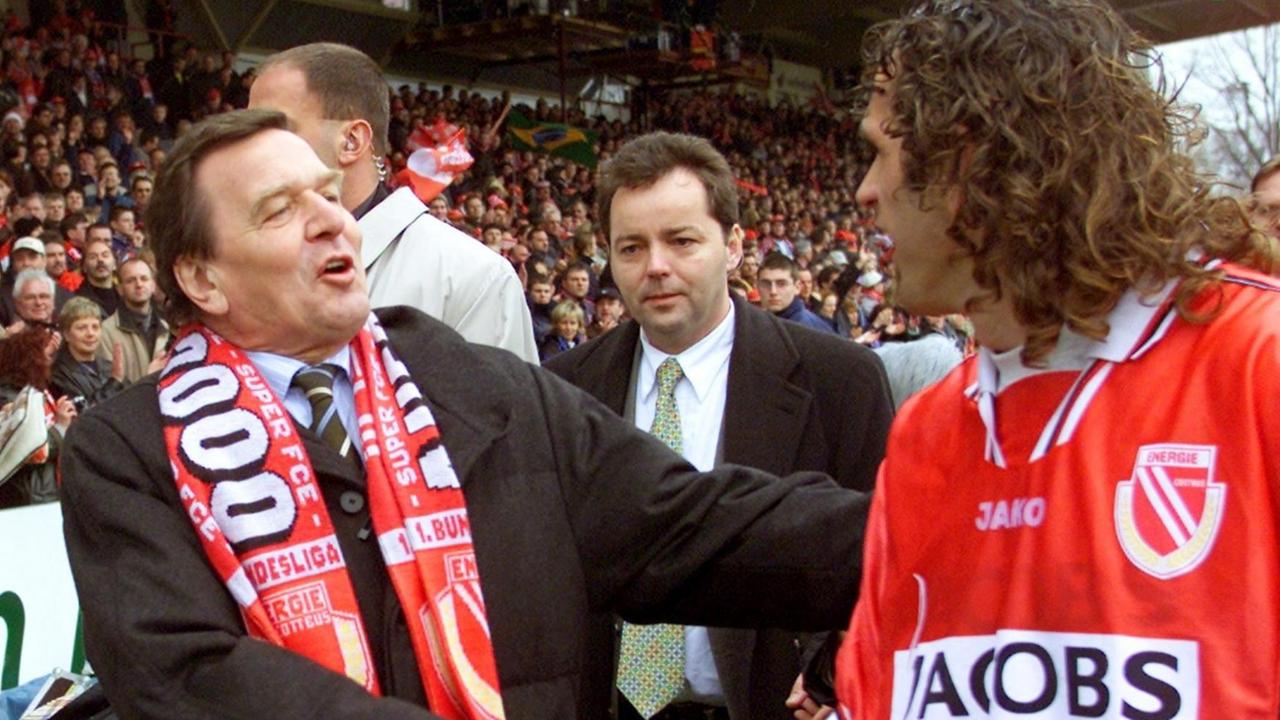 Überschwänglich gratuliert Bundeskanzler Gerhard Schröder (l.) am 21.4.2001 dem Spieler von Energie Cottbus, Bruno Akrapovic, zum 1:0-Sieg im Abstiegsduell gegen die SpVgg Unterhaching. Überschwänglich gratuliert Bundeskanzler Gerhard Schröder (l.) am 21.4.2001 dem Spieler von Energie Cottbus, Bruno Akrapovic, zum 1:0-Sieg im Abstiegsduell gegen die SpVgg Unterhaching.