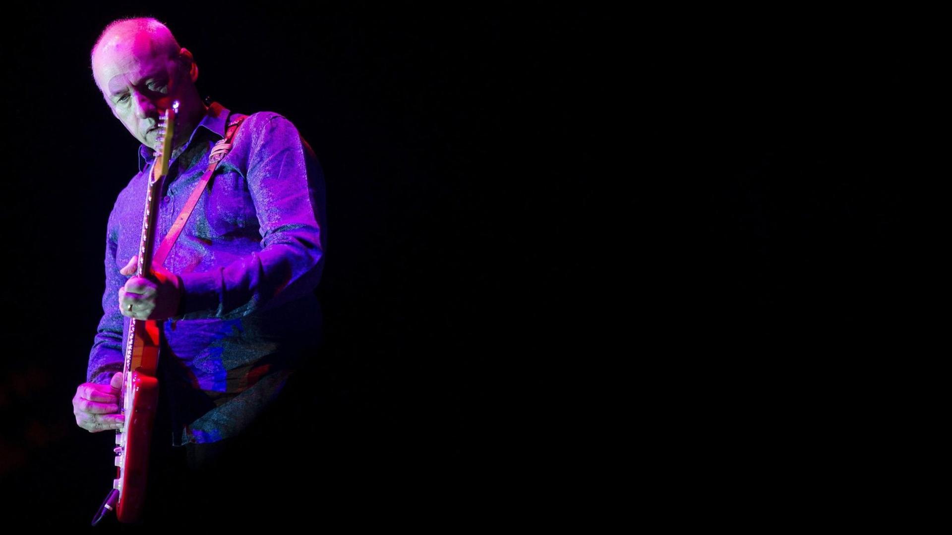 Der Sänger, Gitarrist und Songschreiber Mark Knopfler steht violett-pink angestrahlt während eines Konzerts im spanischen Malaga auf der Bühne. Der Sänger, Gitarrist und Songschreiber Mark Knopfler steht violett-pink angestrahlt während eines Konzerts im spanischen Malaga auf der Bühne.