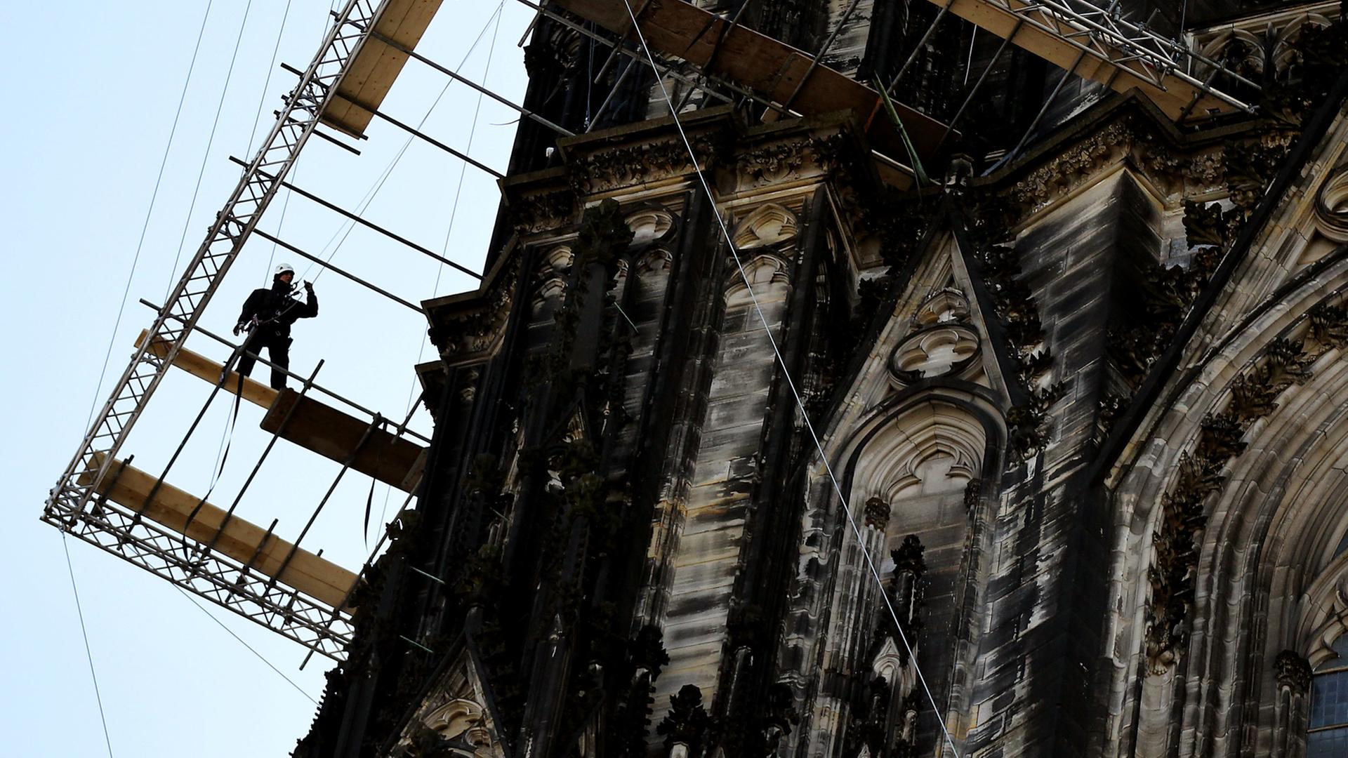 Ein Gerüstbauer arbeitet in Köln auf einem Gerüst am Nordturm des Domes. Ein Gerüstbauer arbeitet in Köln auf einem Gerüst am Nordturm des Domes.