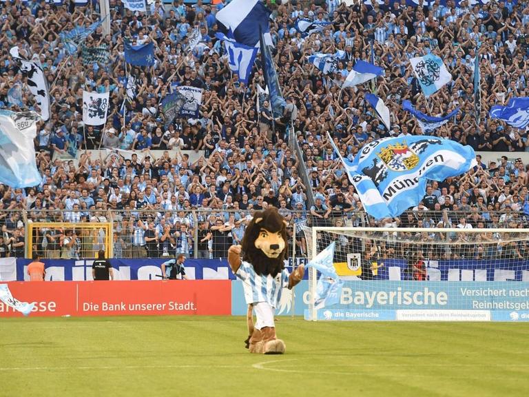 Maskottchen und Fans mit Fahnen sowie die Anzeigetafel mit Endergebnis 3:1 im Stadion an der Grünwalder Straße in München beim Spiel von TSV 1860 München gegen Wacker Biughausen.