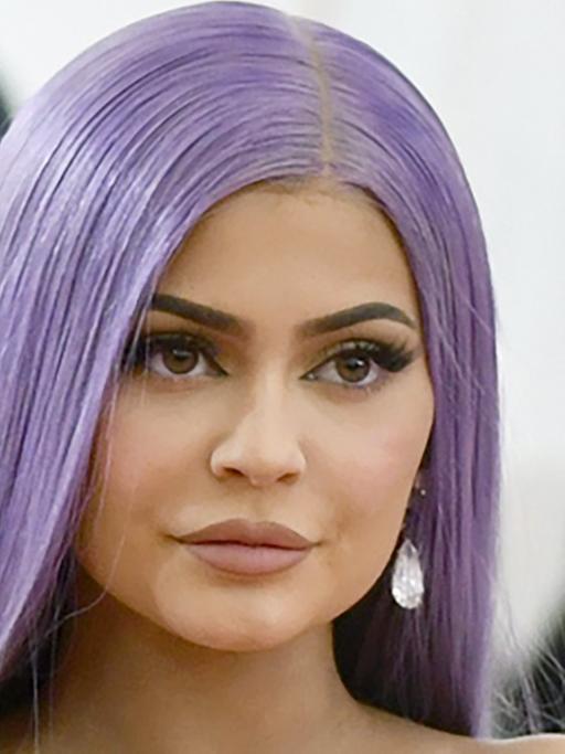 Eine Frau mit lila Haaren und starken Make-up schaut in die Kamera. Es handelt sich um Kylie Jenner.