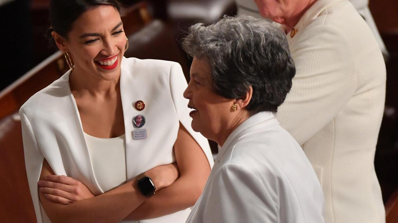 Die demokratische Kongressabgeordnete Alexandria Ocasio-Cortez lacht, als sie mit Kolleginnen spricht - alle in Weiß gekleidet Die demokratische Kongressabgeordnete Alexandria Ocasio-Cortez lacht, als sie mit Kolleginnen spricht - alle in Weiß gekleidet
