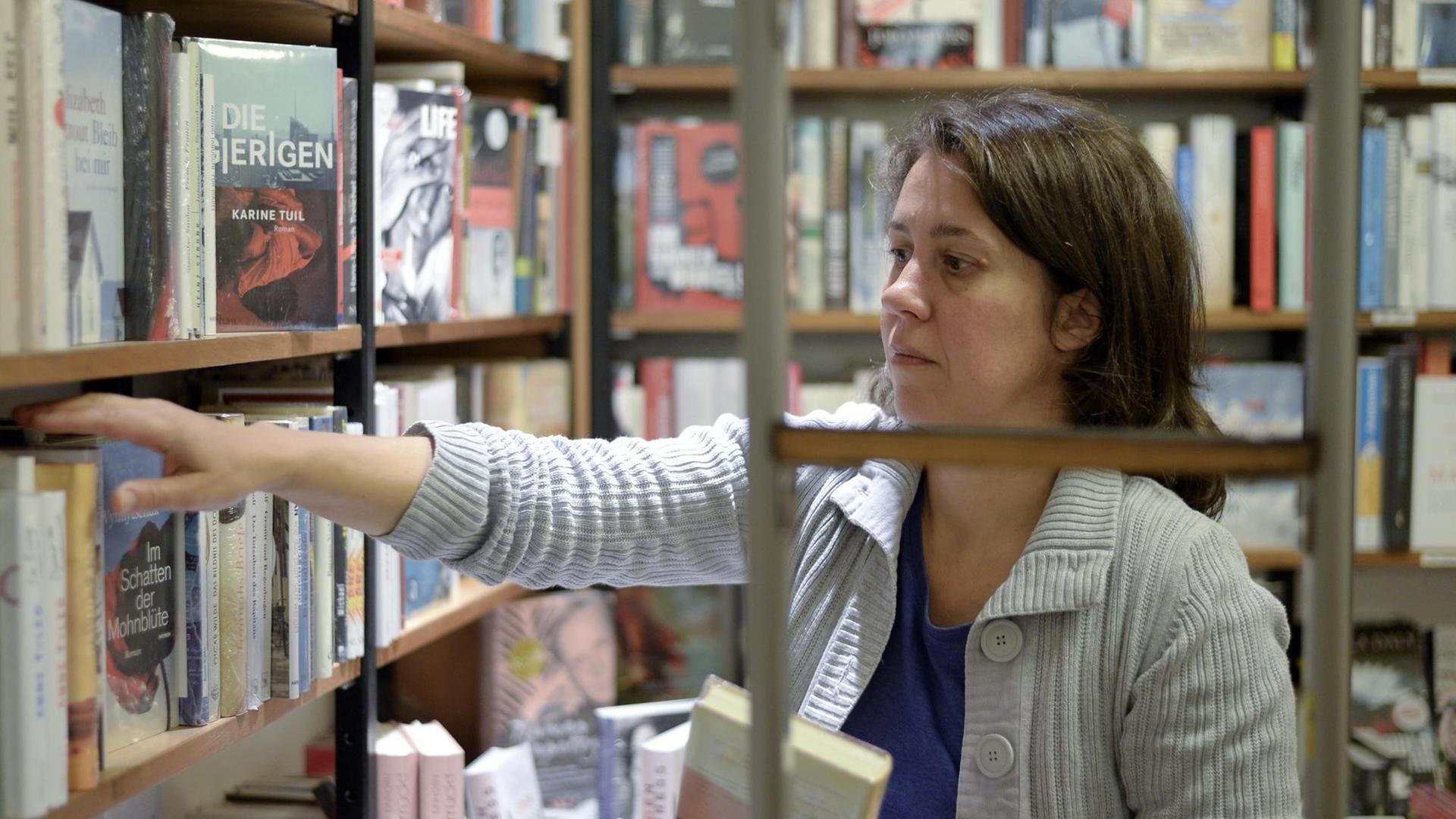 Die Buchhändlerin und Buchpreis-Jurorin Petra Hartlieb greift in ein Regal im Buchladen. Die Buchhändlerin und Buchpreis-Jurorin Petra Hartlieb greift in ein Regal im Buchladen.