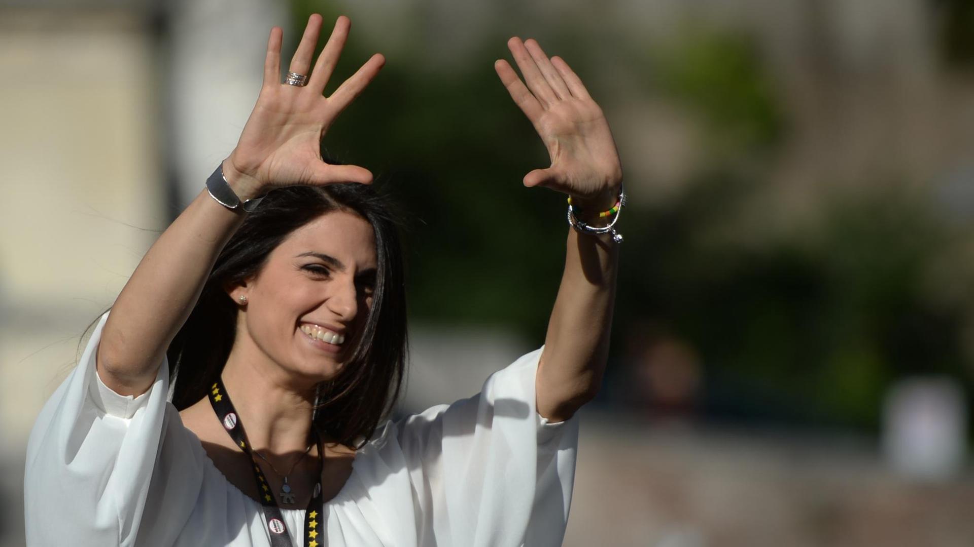 Virginia Raggi strahlt und reckt ihre Hände in die Höhe. Virginia Raggi strahlt und reckt ihre Hände in die Höhe.