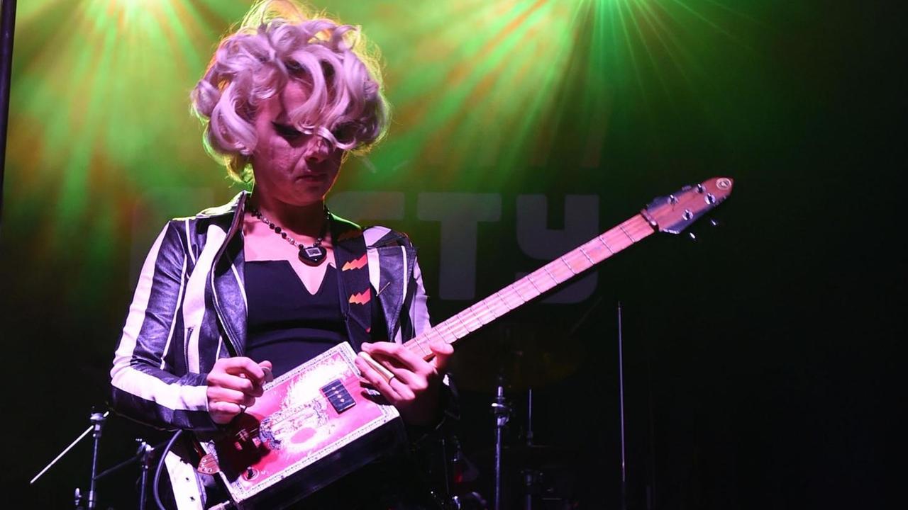 Samantha Fox spielt auf einer Bühne Gitarre.