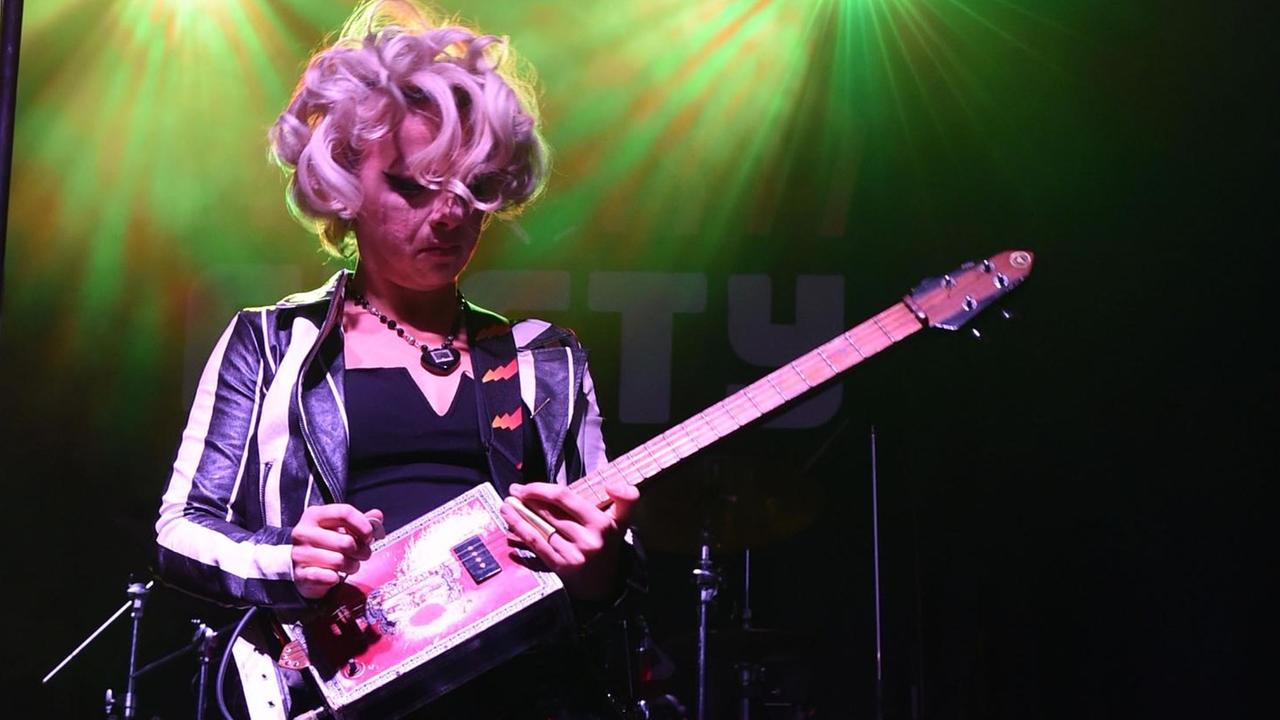 Samantha Fox spielt auf einer Bühne Gitarre. Samantha Fox spielt auf einer Bühne Gitarre.