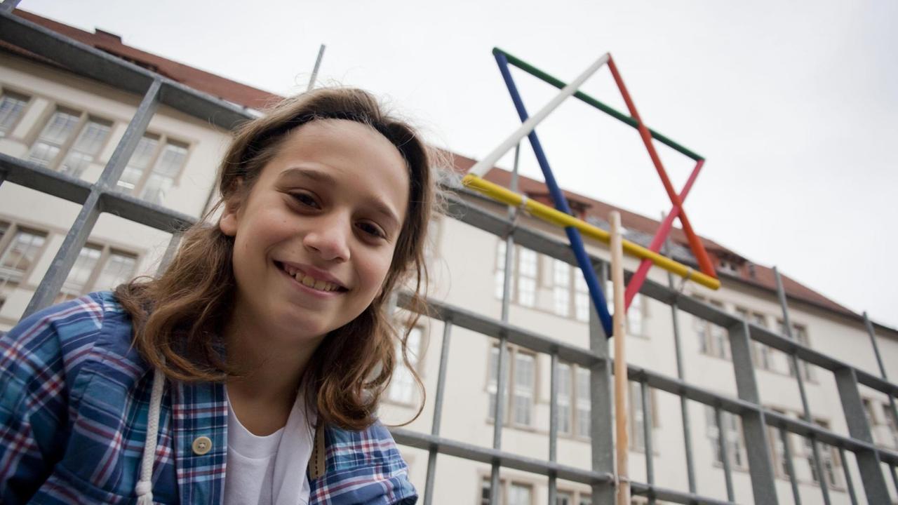Ein Schüler der Lichtigfeld-Schule in Frankfurt am Main steht vor einem Davidstern an der Schule.
