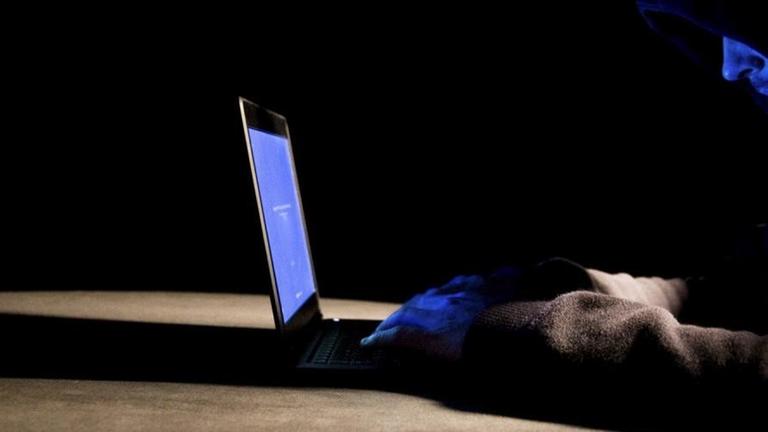 Ein Hacker mit Kapuzenpullover arbeitet an seinem Laptop Ein Hacker mit Kapuzenpullover arbeitet an seinem Laptop
