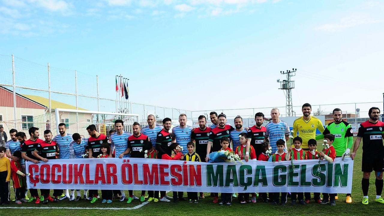 Die Spieler des kurdischen Fußballvereins Amedspor aus Diyarbakir halten vor dem Match mit dem Klub Fenerbahce in Istanbul ein Transparent auf dem auf türkisch steht "Kinder sollten nicht sterben, sondern zu Fußballspielen gehen". Die Spieler des kurdischen Fußballvereins Amedspor aus Diyarbakir halten vor dem Match mit dem Klub Fenerbahce in Istanbul ein Transparent auf dem auf türkisch steht "Kinder sollten nicht sterben, sondern zu Fußballspielen gehen".