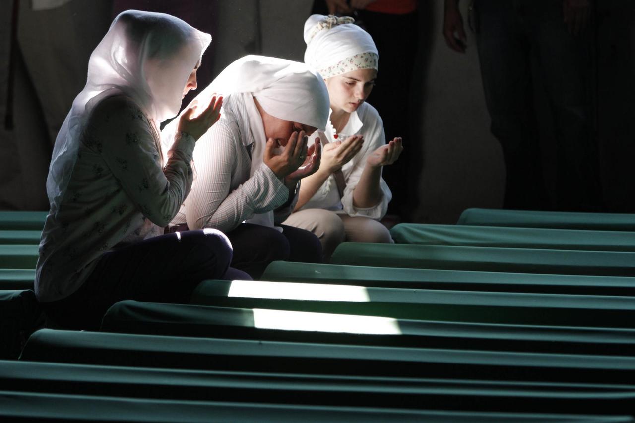 Bosnische Muslimas beten in Potocari (Bosnien) vor Särgen von Opfern des Massakers von Srebrenica die in einer Gedenkstätte aufgestellt wurden. Bosnische Muslimas beten in Potocari (Bosnien) vor Särgen von Opfern des Massakers von Srebrenica die in einer Gedenkstätte aufgestellt wurden.