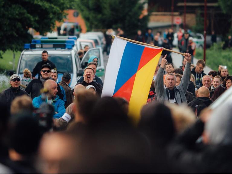 Flüchtlingsgegner protestieren mit einer deutsch-russischen Fahne vor einer Unterkunft von Asylbewerbern in Freital.