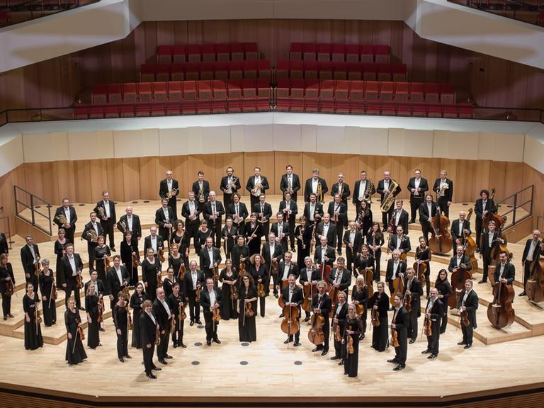 Das Orchester steht in Konzertkleidung auf der Bühne des Dresdner Kulturpalastes.