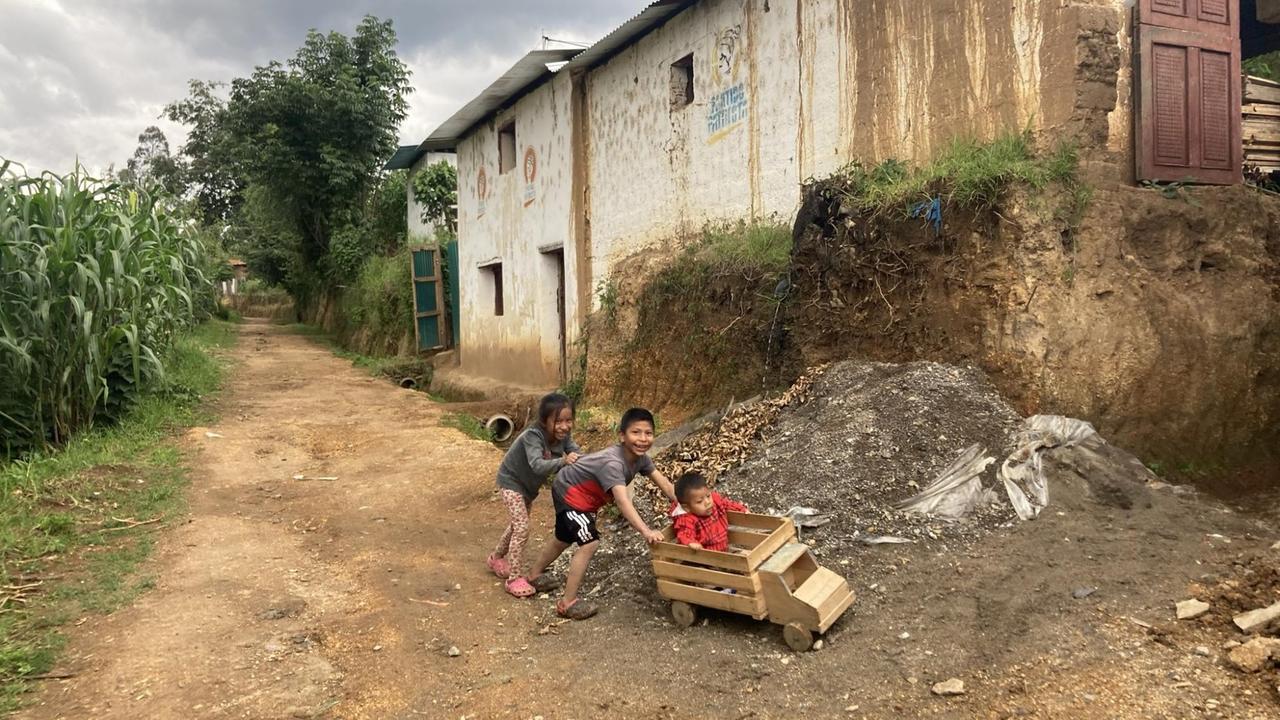 Kinder spielen vor Häusern in Comitancillo.