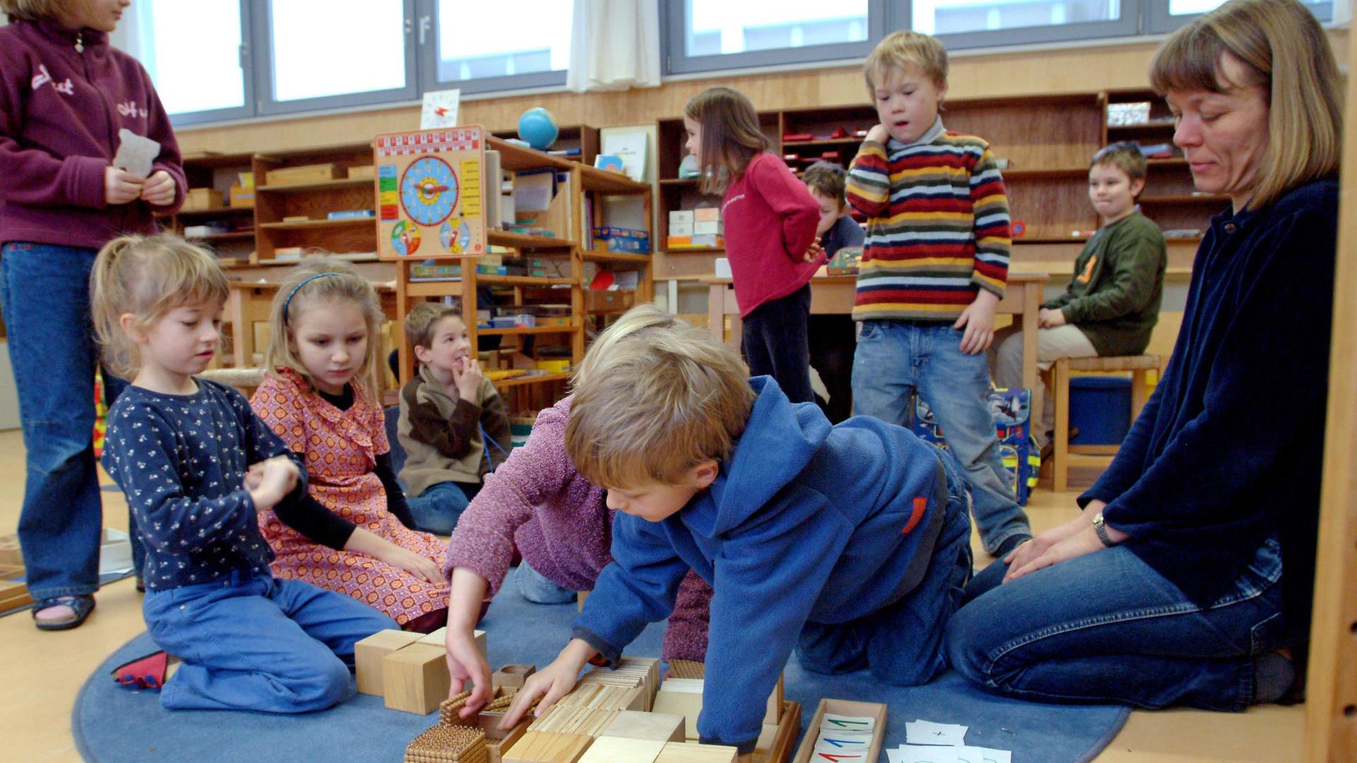 Dresden/Sachsen: Die Erstklässler Janne, Magdalena und Frederik (v.l.) üben mit Lehrerin Brigitte Preuß und dem Perlenspiel in der Montessorischule die Addition. In der Lerngruppe der Kichererbsen sind Kinder der ersten bis vierten Klasse zusammen. Dresden/Sachsen: Die Erstklässler Janne, Magdalena und Frederik (v.l.) üben mit Lehrerin Brigitte Preuß und dem Perlenspiel in der Montessorischule die Addition. In der Lerngruppe der Kichererbsen sind Kinder der ersten bis vierten Klasse zusammen.