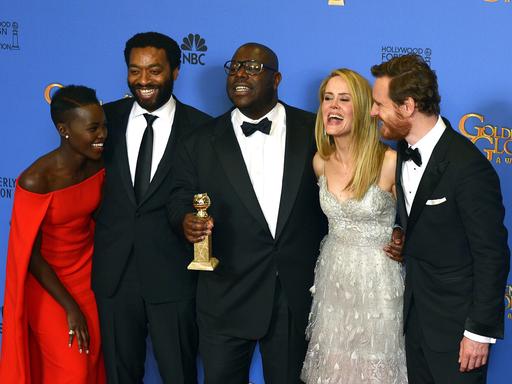 Filmregisseur Steve McQueen (Mitte) hält den Golden Globe für das beste Drama in den Händen. Neben ihm die Schauspielerin Lupita Nyong'o, Chiwetel Ejiofor, Sarah Paulson und Michael Fassbender.