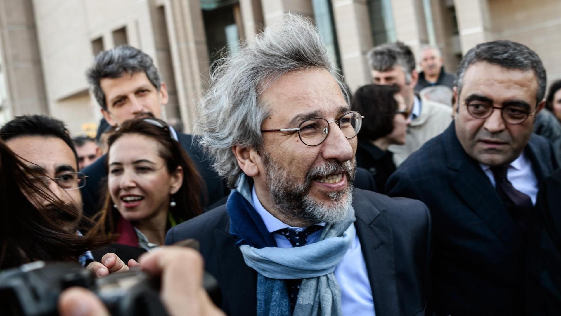 Can Dündar, Chefredakteur der Zeitung "Cumhuriyet", bahnt sich am 1. April den Weg durch Fotografen vor einem Istanbuler Gerichtsgebäude. Can Dündar, Chefredakteur der Zeitung "Cumhuriyet", bahnt sich am 1. April den Weg durch Fotografen vor einem Istanbuler Gerichtsgebäude.