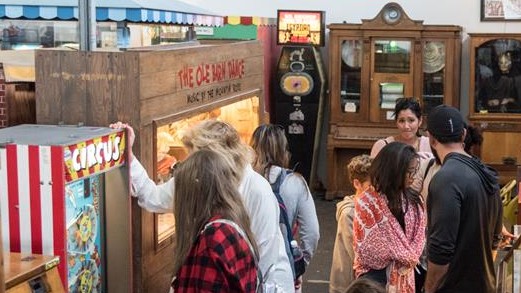 Besucher des Museums bewegen sich durch einen Gang, der links und rechts diverse Automaten zum Ausprobieren bietet. Besucher des Museums bewegen sich durch einen Gang, der links und rechts diverse Automaten zum Ausprobieren bietet.
