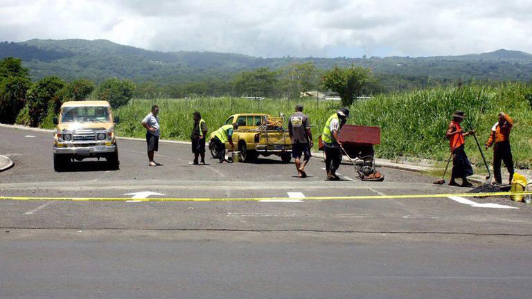 Straßenarbeiter ändern die Markierungen auf einer Straße in Samoa, kurz vor dem Wechsel von Rechts- auf Linksverkehr im Jahr 2009. Straßenarbeiter ändern die Markierungen auf einer Straße in Samoa, kurz vor dem Wechsel von Rechts- auf Linksverkehr im Jahr 2009.