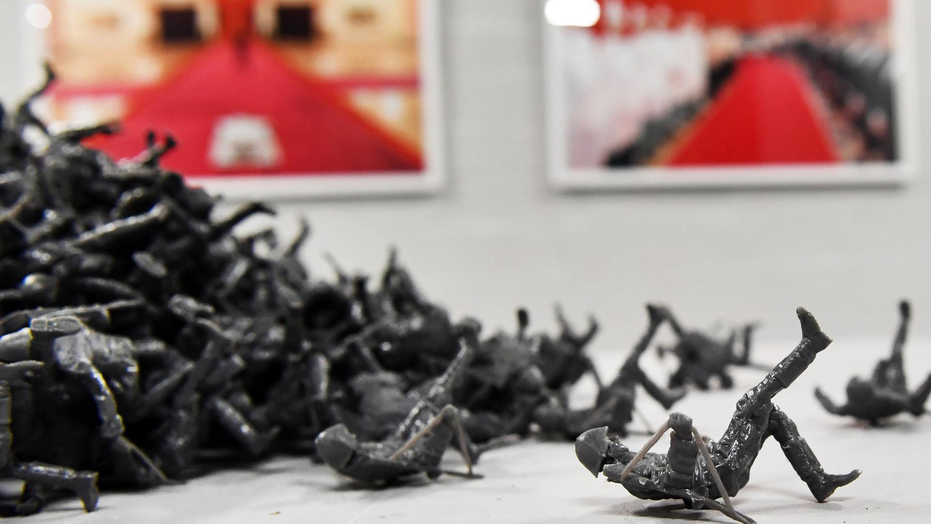 Das Kunstwerk "Mauerspringer" von Fernando Sanchez Castillo aus kleinen Soldaten-Figuren bei der "Ostrale" im Jahr 2017. Die neun Zentimeter großen Figuren des Mannes, der beim Sprung über die Berliner Mauer fotografiert wurde, können mitgenommen werden. Das Kunstwerk "Mauerspringer" von Fernando Sanchez Castillo aus kleinen Soldaten-Figuren bei der "Ostrale" im Jahr 2017. Die neun Zentimeter großen Figuren des Mannes, der beim Sprung über die Berliner Mauer fotografiert wurde, können mitgenommen werden.