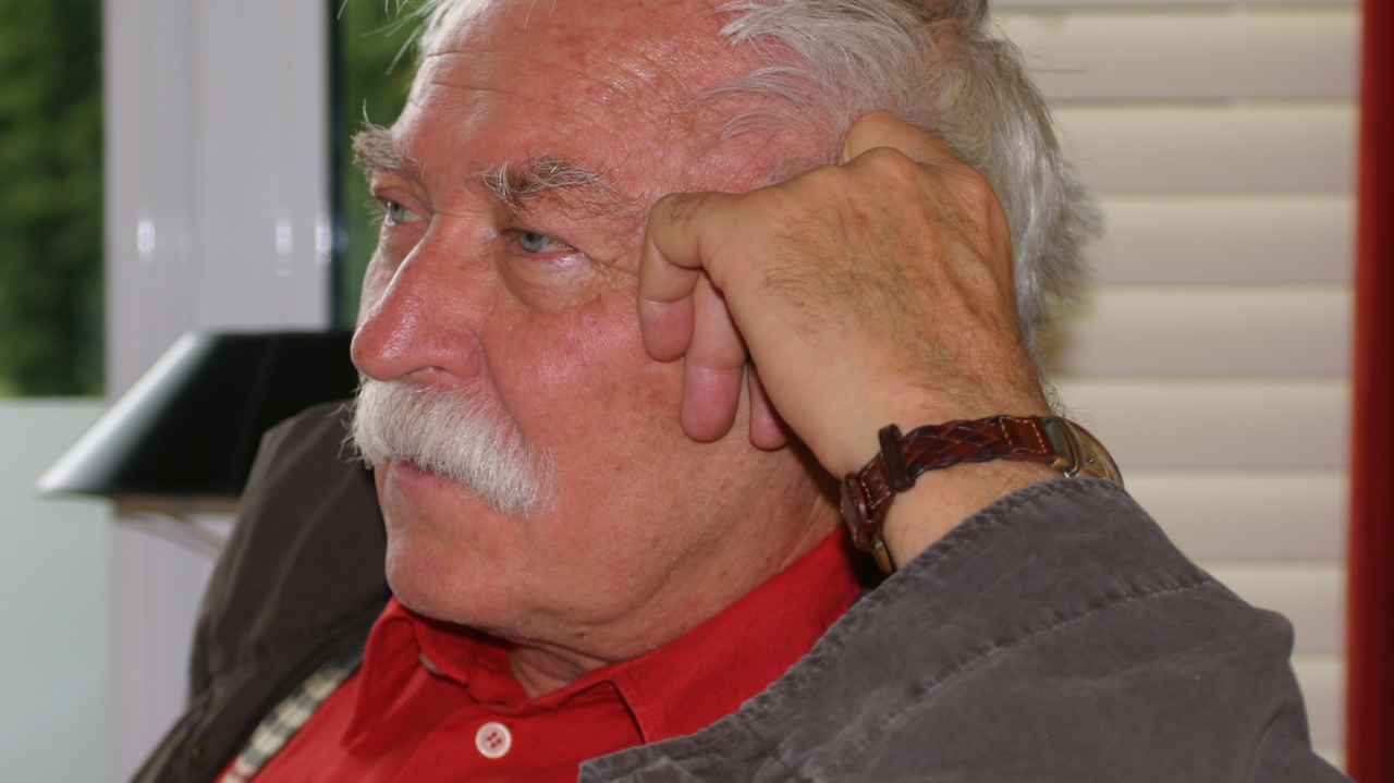 Porträt des Schriftstellers Janosch: Er hat den Kopf auf die linke Hand gestützt.