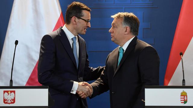 Der Premierminister Polens Mateusz Morawiecki und Ungarns Viktor Orban beim Handschlag im ungarischen Parlament