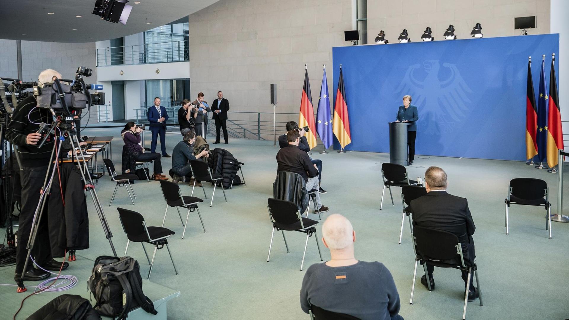 Bundeskanzlerin Merkel spricht auf einer Pressekonferenz zu Journalisten, die weit entfernt voneinander sitzen. Bundeskanzlerin Merkel spricht auf einer Pressekonferenz zu Journalisten, die weit entfernt voneinander sitzen.