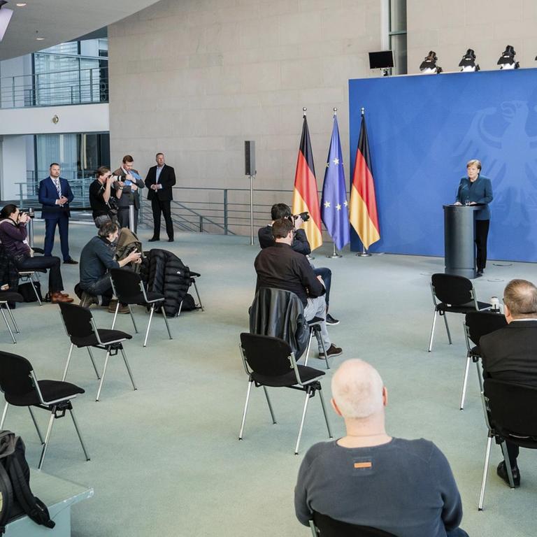 Bundeskanzlerin Merkel spricht auf einer Pressekonferenz zu Journalisten, die weit entfernt voneinander sitzen.