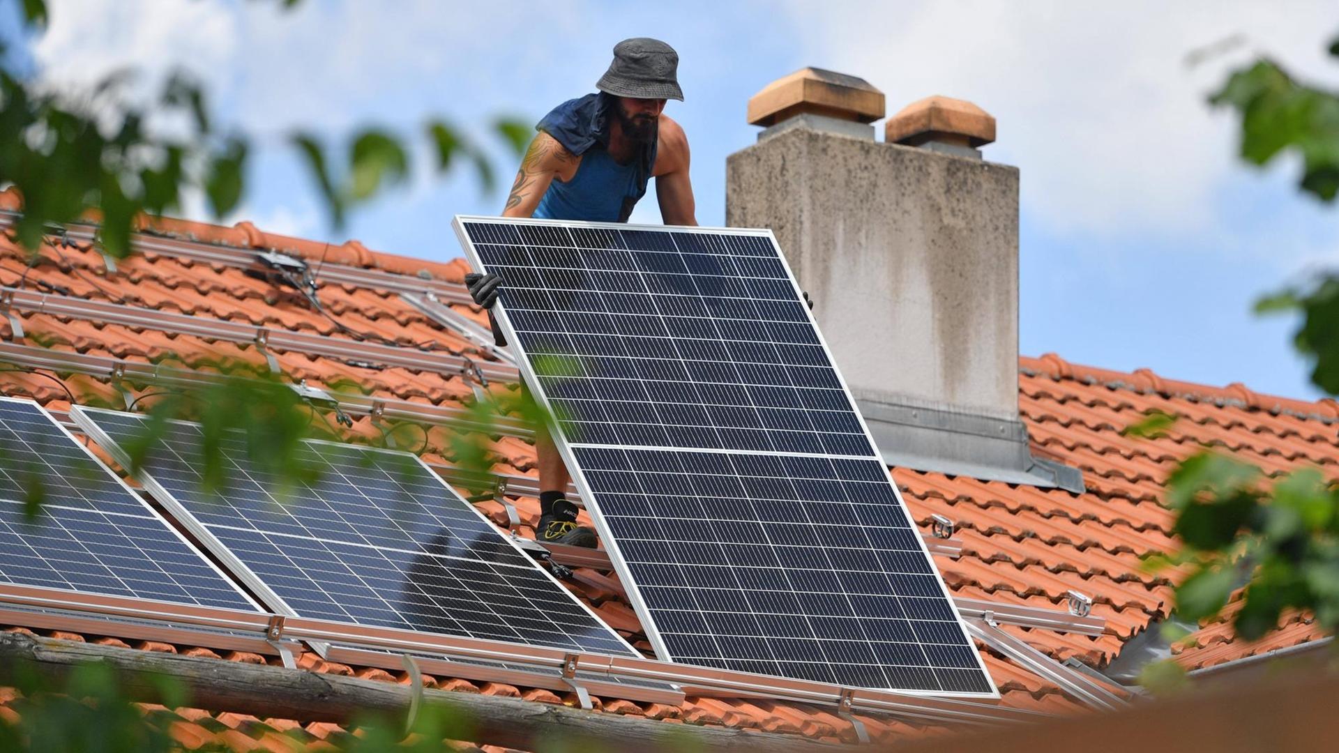 Solarmodule werden auf ein Hausdach transportiert. Ein Arbeiter traegt ein Solarpanel,Solarmodul auf ein Dach eines Wohnhauses. Solarstrom,Solarenergie *** Solar modules are transported on the roof of a house A worker carries a solar panel,solar module on the roof of a house Solar power,solar energy Solarmodule werden auf ein Hausdach transportiert. Ein Arbeiter traegt ein Solarpanel,Solarmodul auf ein Dach eines Wohnhauses. Solarstrom,Solarenergie *** Solar modules are transported on the roof of a house A worker carries a solar panel,solar module on the roof of a house Solar power,solar energy