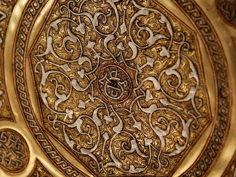 Details einer antiken Messingplatte aus Syrien. Die in Handarbeit enstandene Platte weist Kupfer- und Silbereinlagen auf.