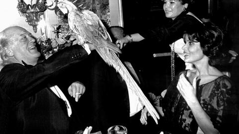 13. Dezember 1975: Zu seinem 60. Geburtstag bekommt Curd Jürgens einen Papagei überreicht. Rechts sitzend: Uschi Glas.