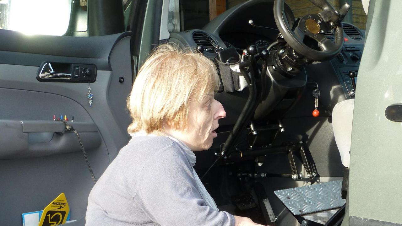Eine kleine Frau steigt auf kleinen Stufen in ein Auto ein. Eine kleine Frau steigt auf kleinen Stufen in ein Auto ein.