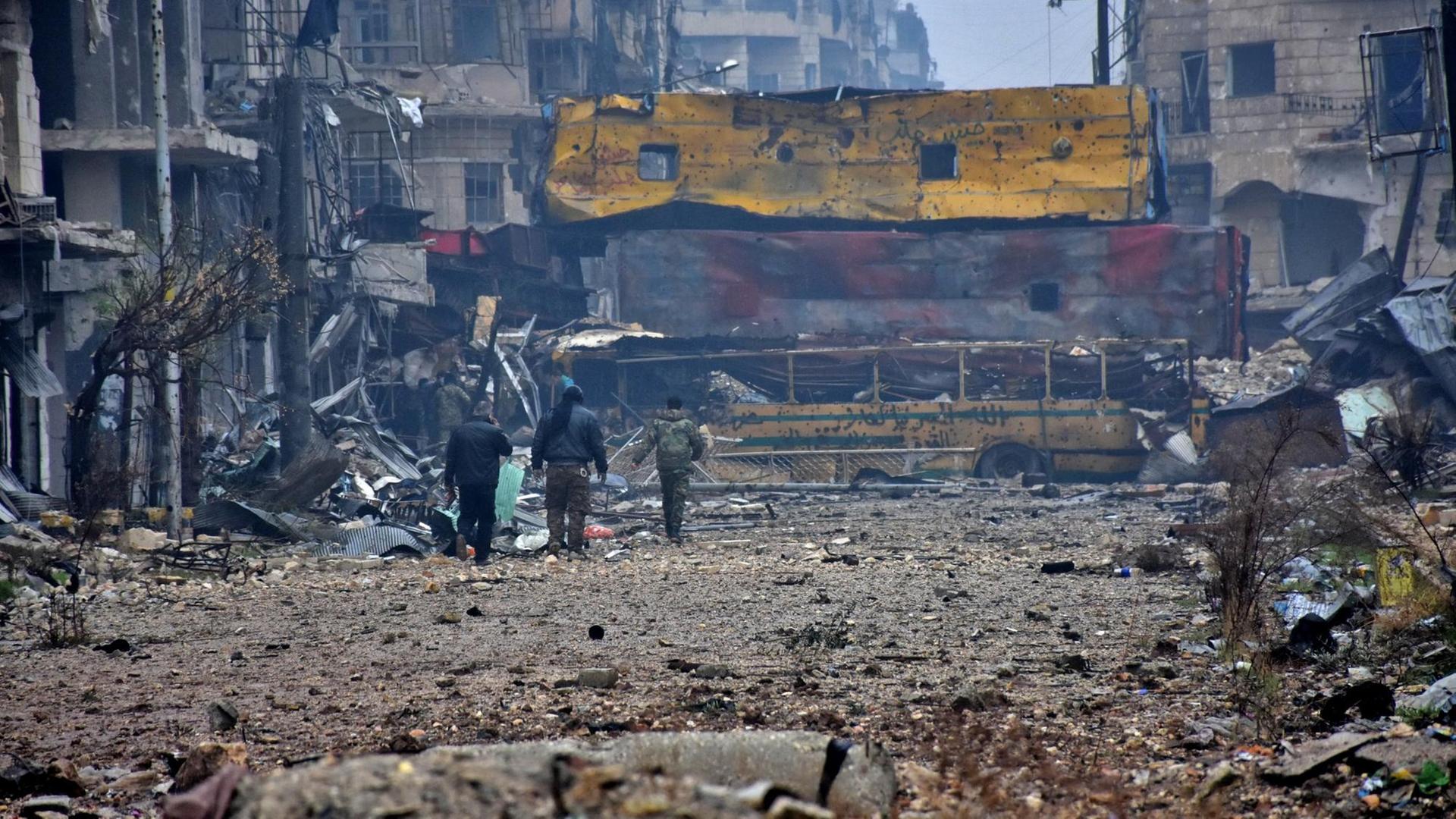 Drei Soldaten gehen durch eine zerstörte Straße durch Aleppo. Drei Soldaten gehen durch eine zerstörte Straße durch Aleppo.