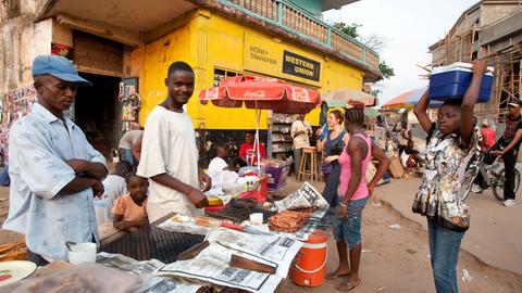 Straßenszene in Makeni, einer Stadt im Nordosten von Sierra Leone - Straßenhändler bieten vor einem Büro von Western Union ihre Waren an.