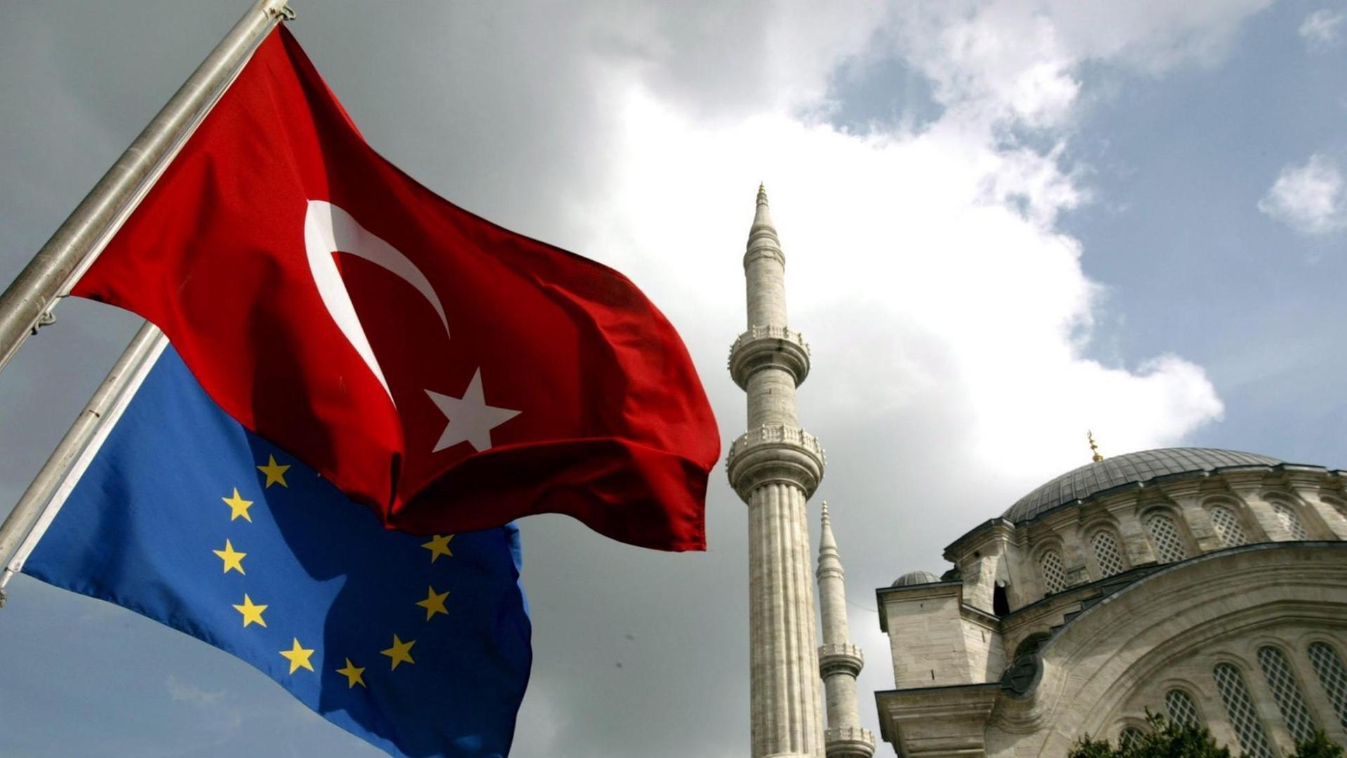 Die türkische und die europäische Flagge wehen vor der Nuruosmaniye-Moschee in Istanbul.