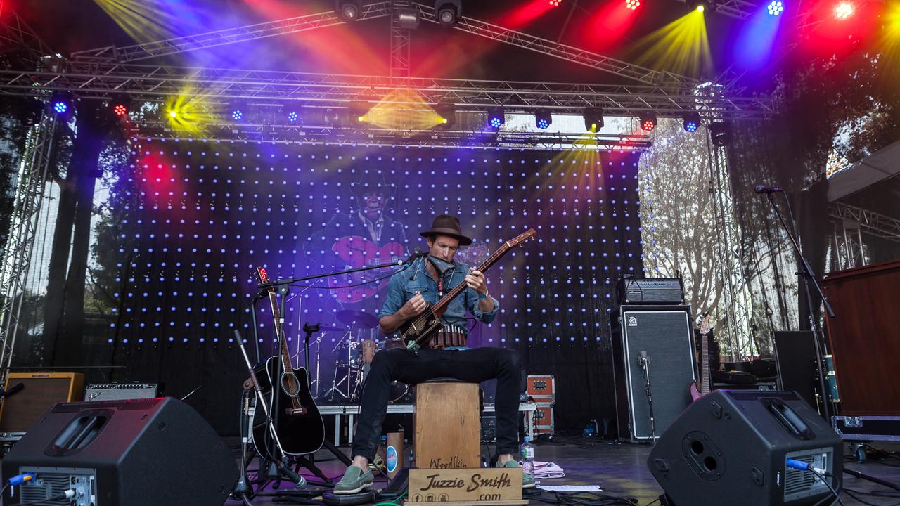 Ein Mann sitzt auf einer Cajon und spielt auf seiner selbstgebauten Cigar-Box-Gitarre. Ein Mann sitzt auf einer Cajon und spielt auf seiner selbstgebauten Cigar-Box-Gitarre.