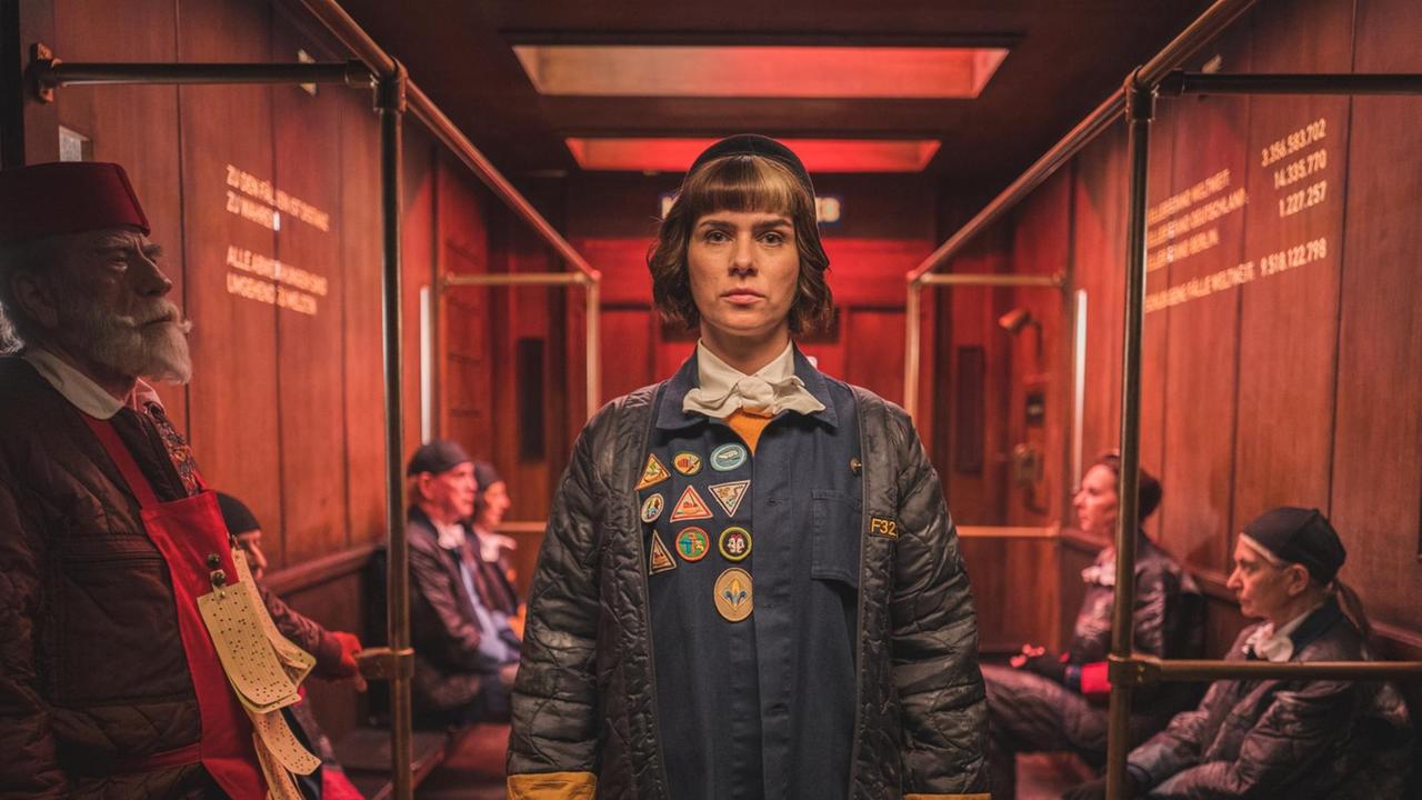 Filmszene aus "The Mopes", Monika (Nora Tschirner) steht in einem rot beleuchteten Fahrstuhl. Filmszene aus "The Mopes", Monika (Nora Tschirner) steht in einem rot beleuchteten Fahrstuhl.