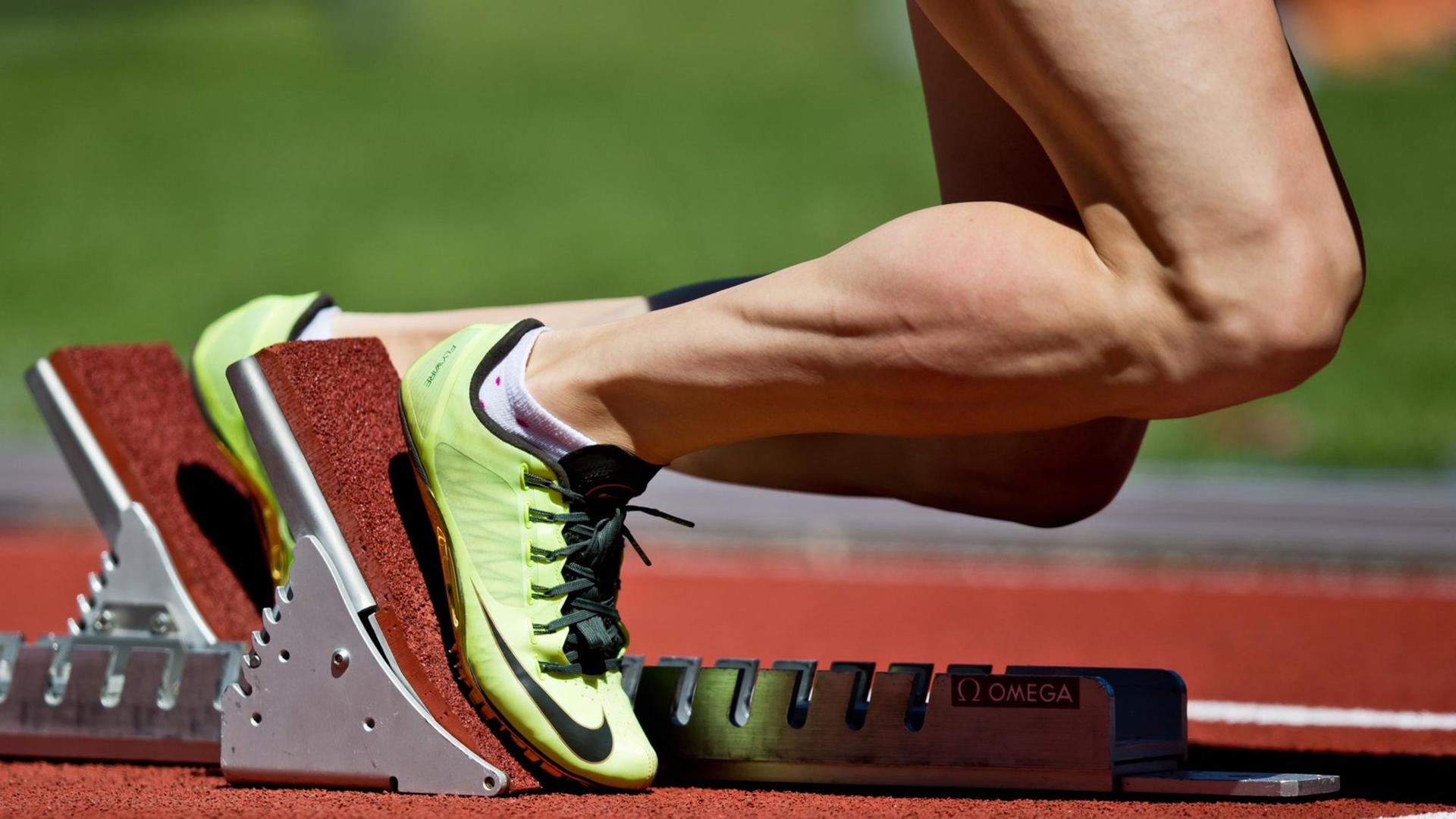 Eine Athletin steht im Startblock für einen 400 Meter Hürdenlauf. Eine Athletin steht im Startblock für einen 400 Meter Hürdenlauf.