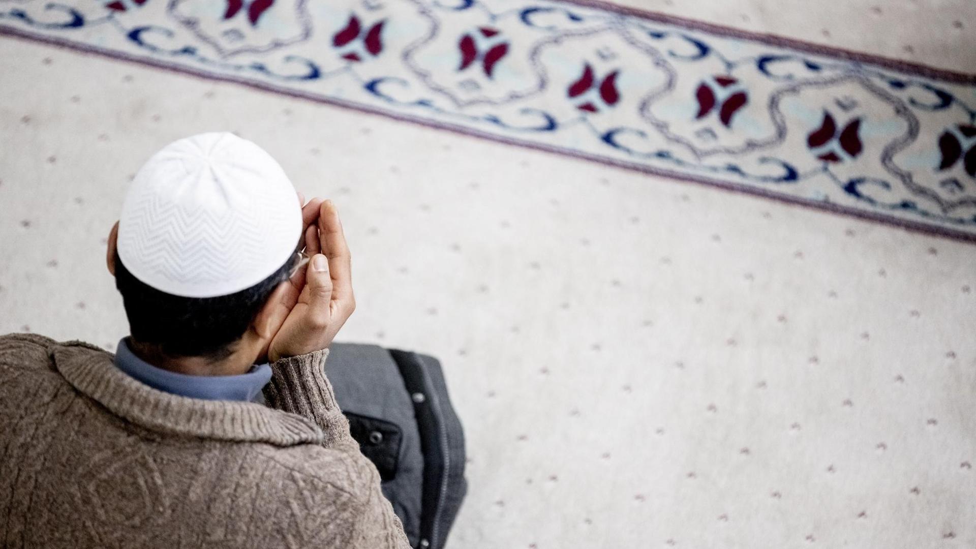 Ein Mann betet in einer Moschee. Ein Mann betet in einer Moschee.
