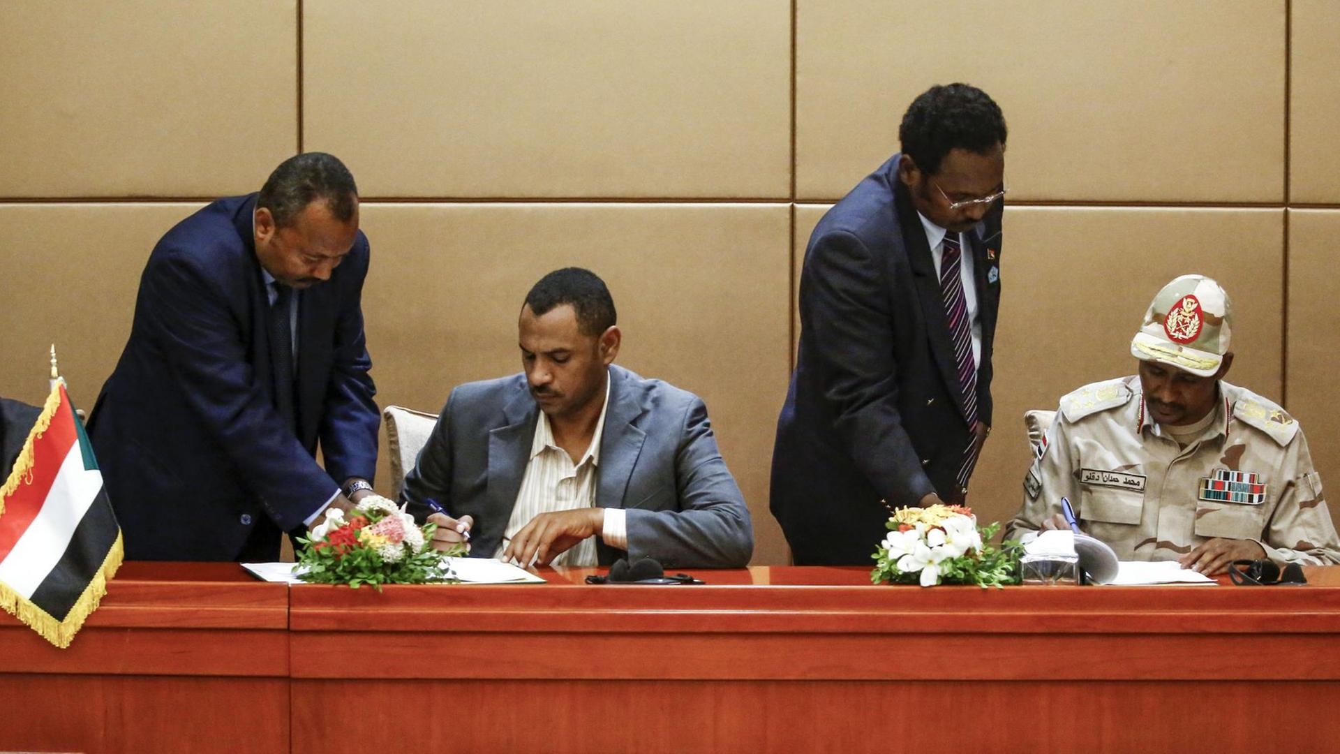 General Mohamed Hamdan Daglo (r.) vom regierenden Übergangs-Militärrat und Ahmed Rabie von der prodemokratischen Protestbewegung unterzeichnen am 4. August 2019 ein Verfassungspapier, um den Weg zu einer Zivilregierung im Sudan freizumachen General Mohamed Hamdan Daglo (r.) vom regierenden Übergangs-Militärrat und Ahmed Rabie von der prodemokratischen Protestbewegung unterzeichnen am 4. August 2019 ein Verfassungspapier, um den Weg zu einer Zivilregierung im Sudan freizumachen