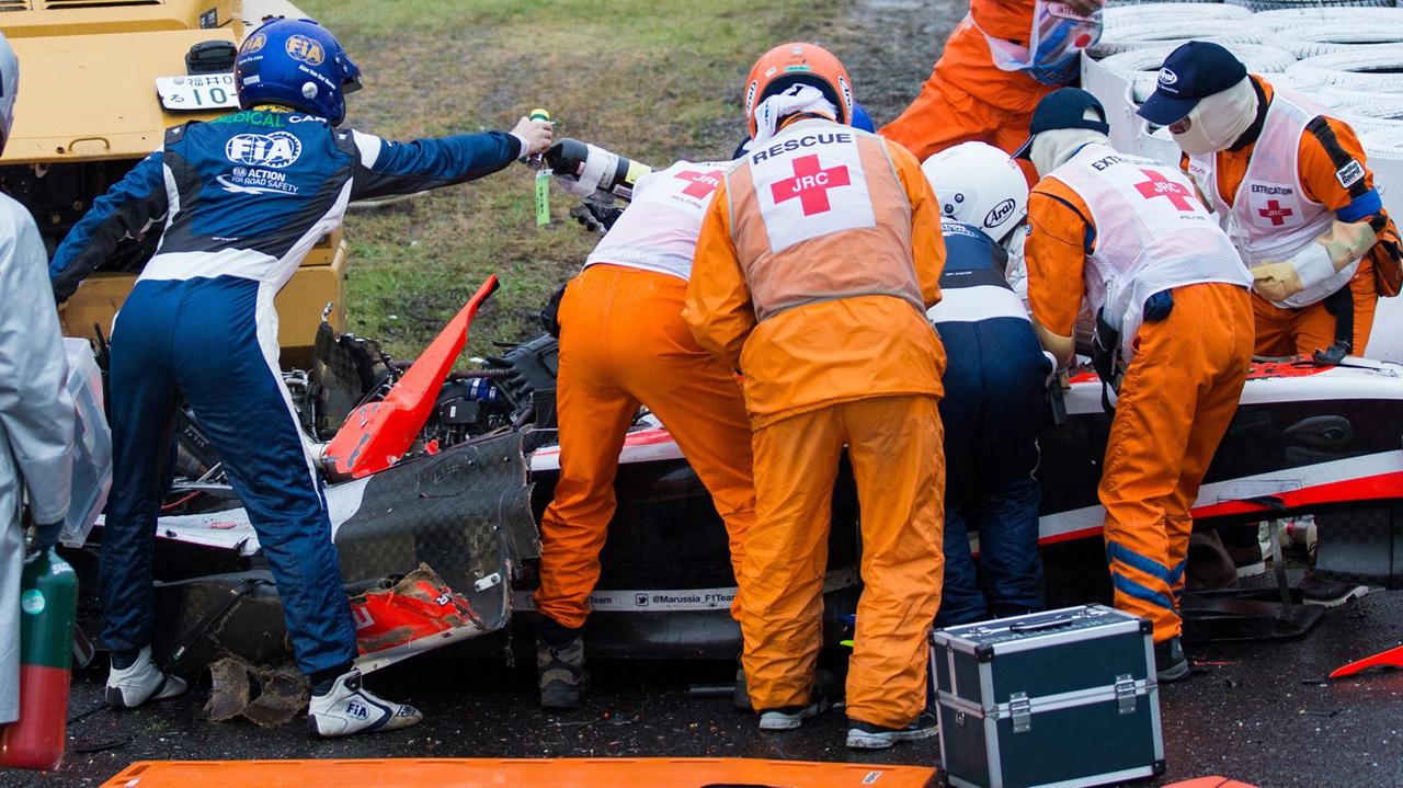 Formel-1-Fahrer Jules Bianchi wurde beim Rennen in Suzuka schwer verletzt. Beim verunglückten Wagen stehen zahlreiche Helfer und Ärzte und leisten erste Hilfe 