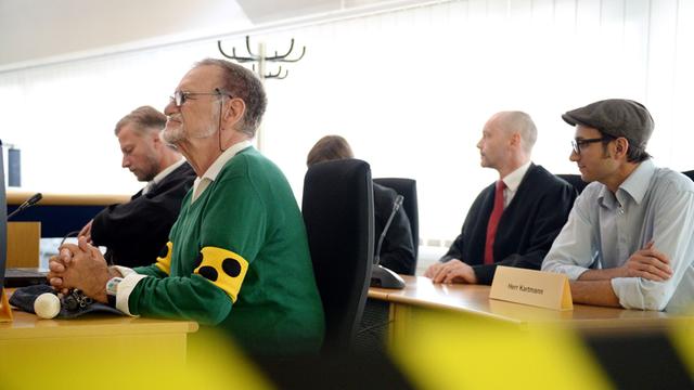 Dietrich Wagner (2.v.l), Nebenkläger im Wasserwerfer-Prozess, sitzt am 24.06.2014 zusammen mit dem Anwalt Frank-Ulrich Mann (l) beim Beginn des Wasserwerfer-Prozesses in einem Gerichtssaal im Landgericht in Stuttgart (Baden-Württemberg).