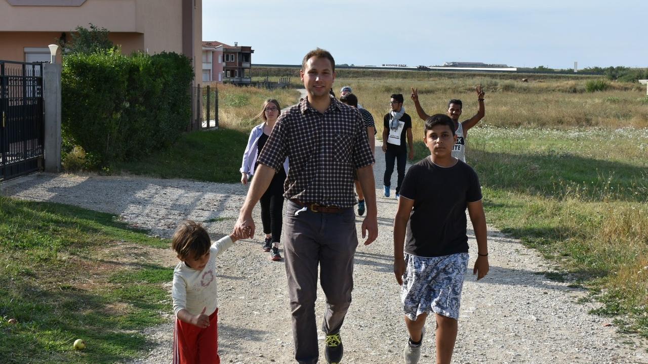 Moritz Kuhlmann geht mit Ashkali-Kindern spazieren - an der Hand hält er einen kleinen Jungen Moritz Kuhlmann geht mit Ashkali-Kindern spazieren - an der Hand hält er einen kleinen Jungen
