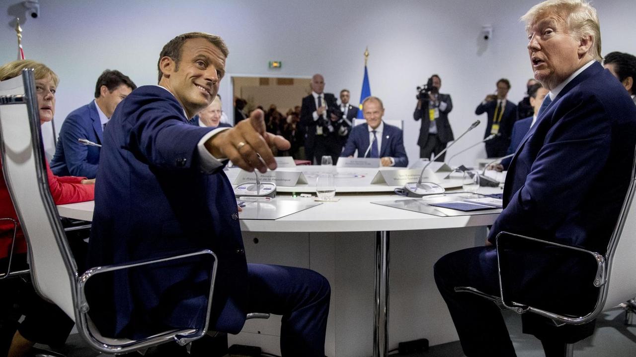 Frankreichs Präsident Emmanuel Macron (links) und US-Präsident Donald Trump am Tisch mit weiteren Staats- und Regierungschefs beim G7-Gipfel in Biarritz