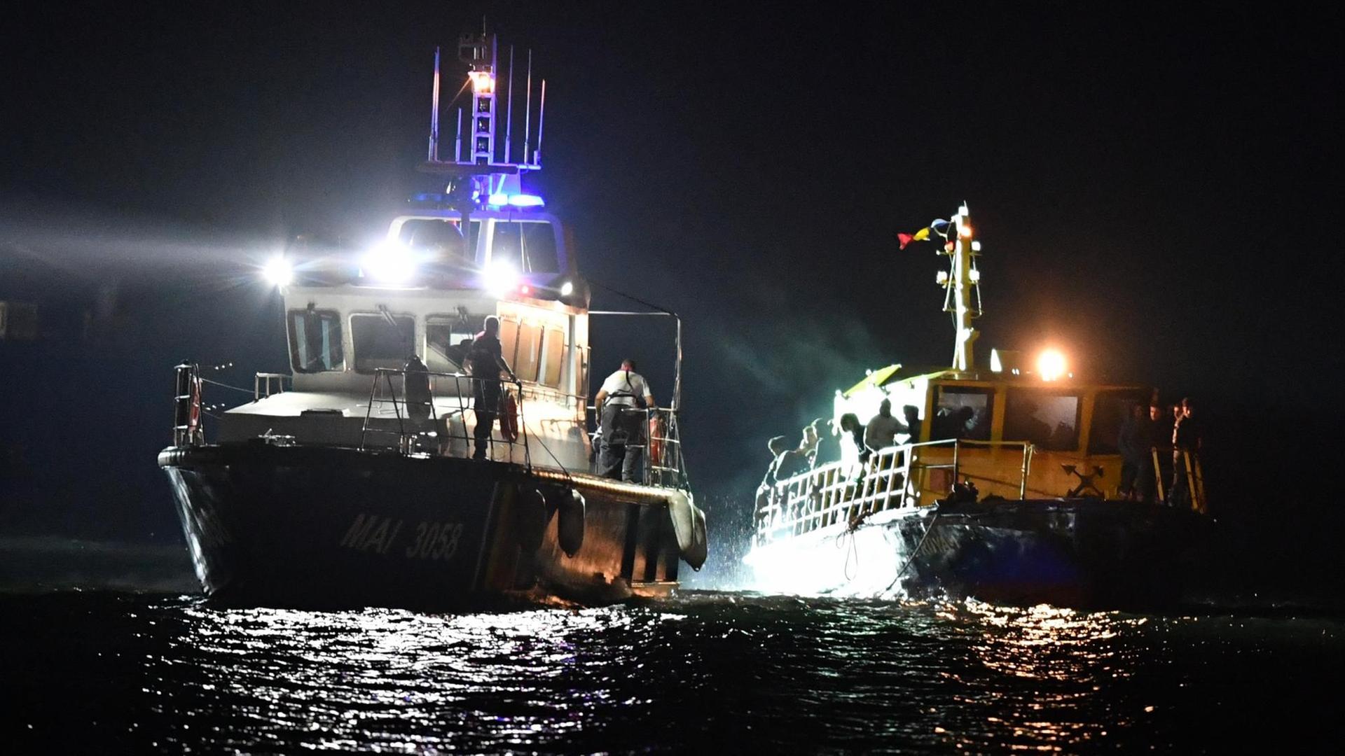 Ein Schiff der rumänischen Küstenwache schleppt ein Flüchtingsboot auf dem Schwarzen Meer ab. Ein Schiff der rumänischen Küstenwache schleppt ein Flüchtingsboot auf dem Schwarzen Meer ab.