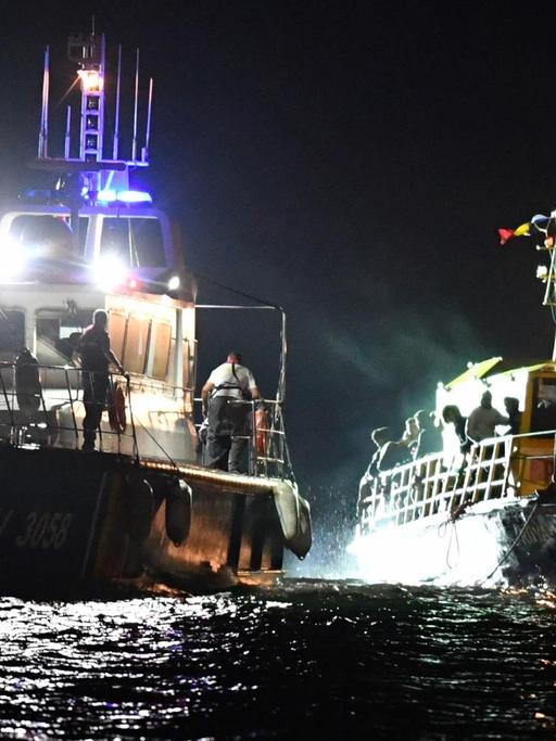 Ein Schiff der rumänischen Küstenwache schleppt ein Flüchtingsboot auf dem Schwarzen Meer ab.