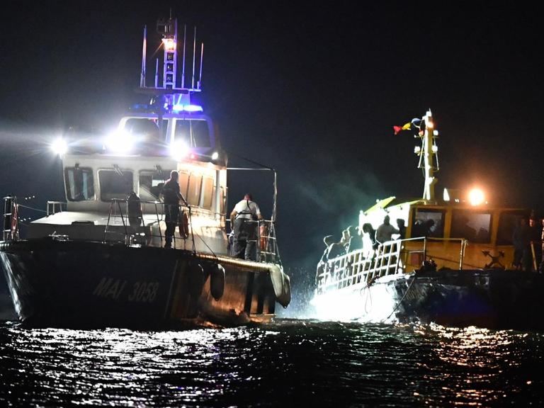 Ein Schiff der rumänischen Küstenwache schleppt ein Flüchtingsboot auf dem Schwarzen Meer ab.