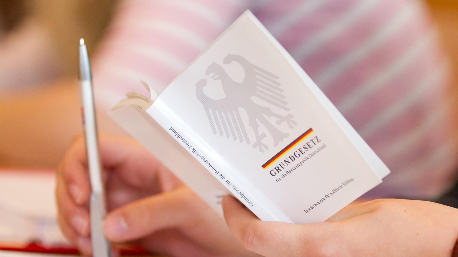 Eine Jura-Studentin hält in einer Vorlesung an der Universität Osnabrück (Niedersachsen) eine Ausgabe vom Grundgesetz in der Hand. Eine Jura-Studentin hält in einer Vorlesung an der Universität Osnabrück (Niedersachsen) eine Ausgabe vom Grundgesetz in der Hand.