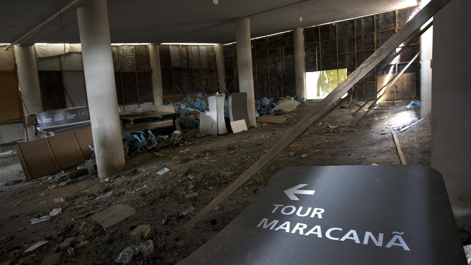 Das Foto zeigt das Innere des Maracana-Stadions in Rio de Janeiro. Der Boden ist mit Schutt bedeckt, ein Hinweisschild liegt auf dem Boden. Das Foto zeigt das Innere des Maracana-Stadions in Rio de Janeiro. Der Boden ist mit Schutt bedeckt, ein Hinweisschild liegt auf dem Boden.