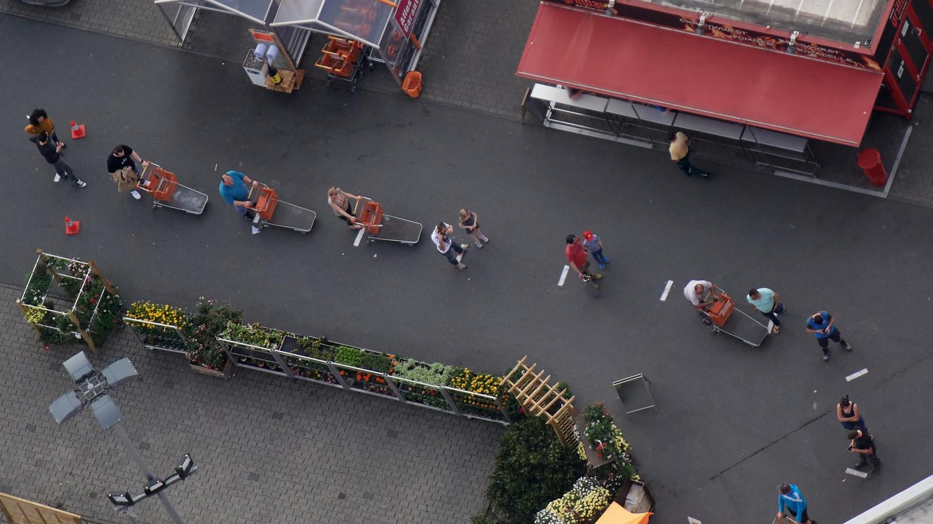 Kunden eines Baumarktes stehen vor dem Eingang mit Abstand in einer Schlange. Zur Eindämmung des Coronavirus hat NRW alle Ansammlungen ab drei Personen in der Öffentlichkeit verboten. Kunden eines Baumarktes stehen vor dem Eingang mit Abstand in einer Schlange. Zur Eindämmung des Coronavirus hat NRW alle Ansammlungen ab drei Personen in der Öffentlichkeit verboten.