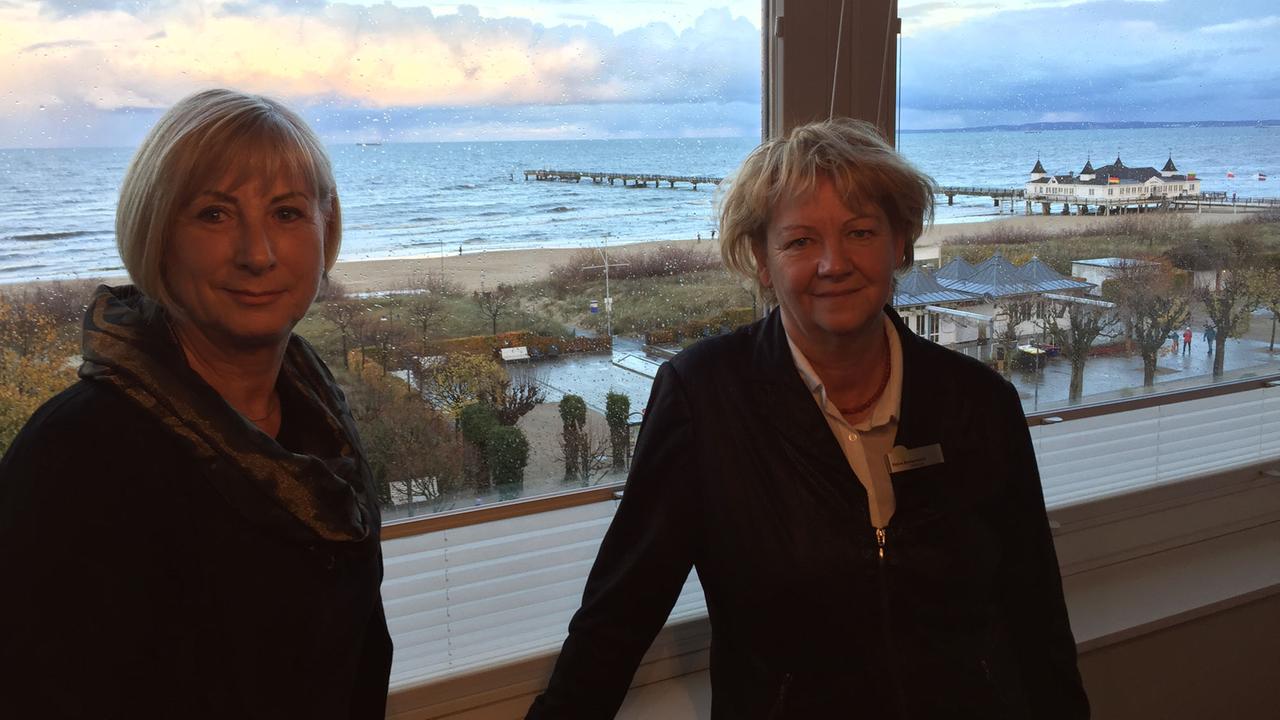 Beate-Carola Johannsen, Vorsitzende des Tourismusverbands Usedom, und Hoteldirektorin Petra Bensemann stehen vor einem Fenster mit Blick aufs Meer. Beate-Carola Johannsen, Vorsitzende des Tourismusverbands Usedom, und Hoteldirektorin Petra Bensemann stehen vor einem Fenster mit Blick aufs Meer.